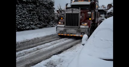 Big Rig Truck pulls 18 wheeler uphill in snow
